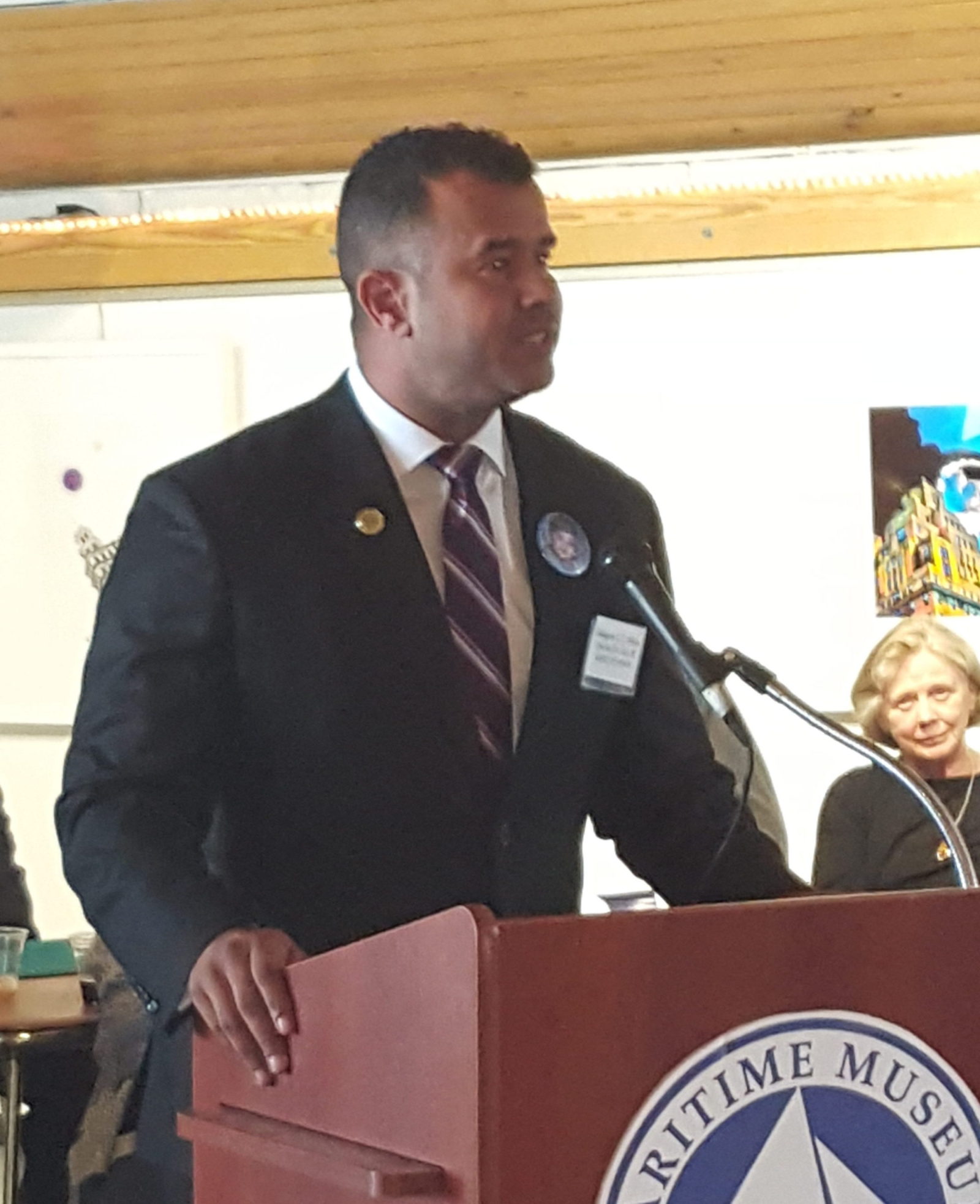 Man in suit giving speech at museum podium