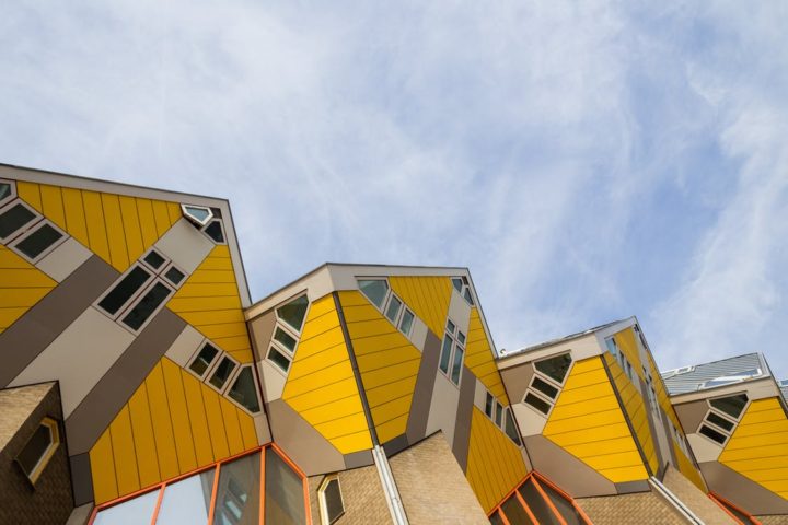 Yellow tilted cube houses against blue sky