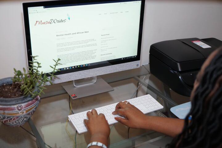 Person typing on desktop computer in home office
