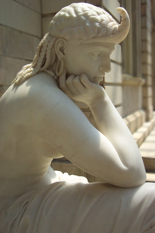 White marble statue of contemplative seated figure